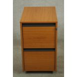 A contemporary teak two drawer filing cabinet on wheels. H.67 W.42 D.60cm.