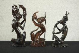 Three assorted Balinese hardwood carvings of assorted musicians each playing different musical