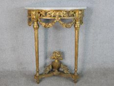 A 19th / early 20th century giltwood and white marble console table, the pierced foliate scroll