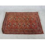 A 20th century handmade Persian Turkaman red ground rug with central lozenge design within geometric