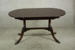 A Regency style extendable dining table raised on turned column standing in four splayed supports