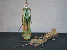 A carved and painted Javanese Wayang shadow puppet doll in silk clothing along with another Javanese