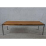 A late 20th century teak coffee table, the rectangular top on a square tubular frame. H.36 W.128 D.