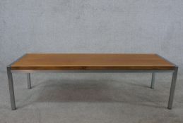 A late 20th century teak coffee table, the rectangular top on a square tubular frame. H.36 W.128 D.