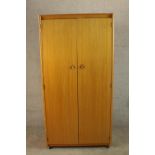 A circa 1960's Schreiber teak wardrobe with a pair of doors, opening to reveal hanging space and