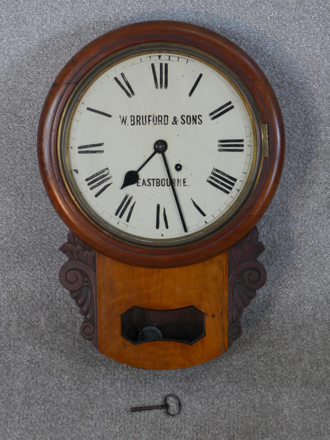 A late 19th/early 20th century drop dial wall clock, the enamelled dial with Roman numerals marked