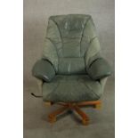 A 20th century pale green leather swival and counter leaver arm chair raised on five splayed