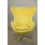 After Arne Jacobsen, a yellow upholstered Egg style chair raised on four chrome plated splayed base.