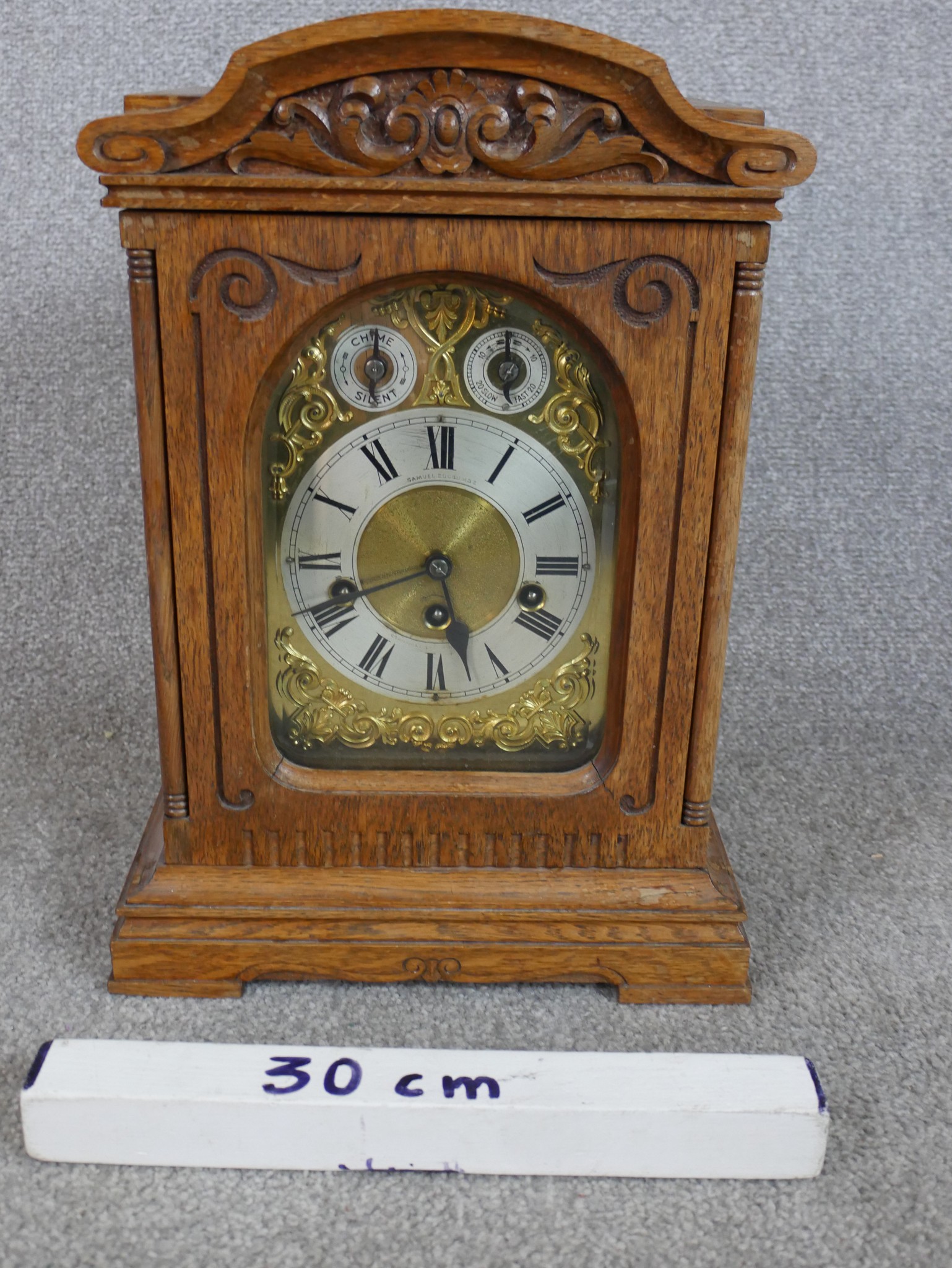 A late 19th / early 20th century carved oak Anfang mantle clock, the brass dial with black Roman