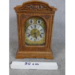 A late 19th / early 20th century carved oak Anfang mantle clock, the brass dial with black Roman