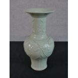 A Chinese celadon glazed porcelain vase, with a flared rim, a slender neck and a bulbous body,