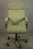 A 20th century upholstered open arm office chair raised central column on five splayed supports