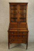 An Arts & Crafts style oak bureau / secretaire bookcase, the dentil freize cornice above two glass