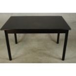 A contemporary ebonised extending drawleaf dining table, the leaf folds in on itself raised on