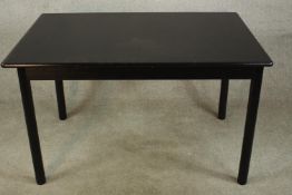 A contemporary ebonised extending drawleaf dining table, the leaf folds in on itself raised on