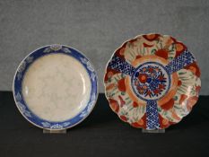 A late 19th/early 20th century Japanese Imari scalloped edged plate decorated with panels of