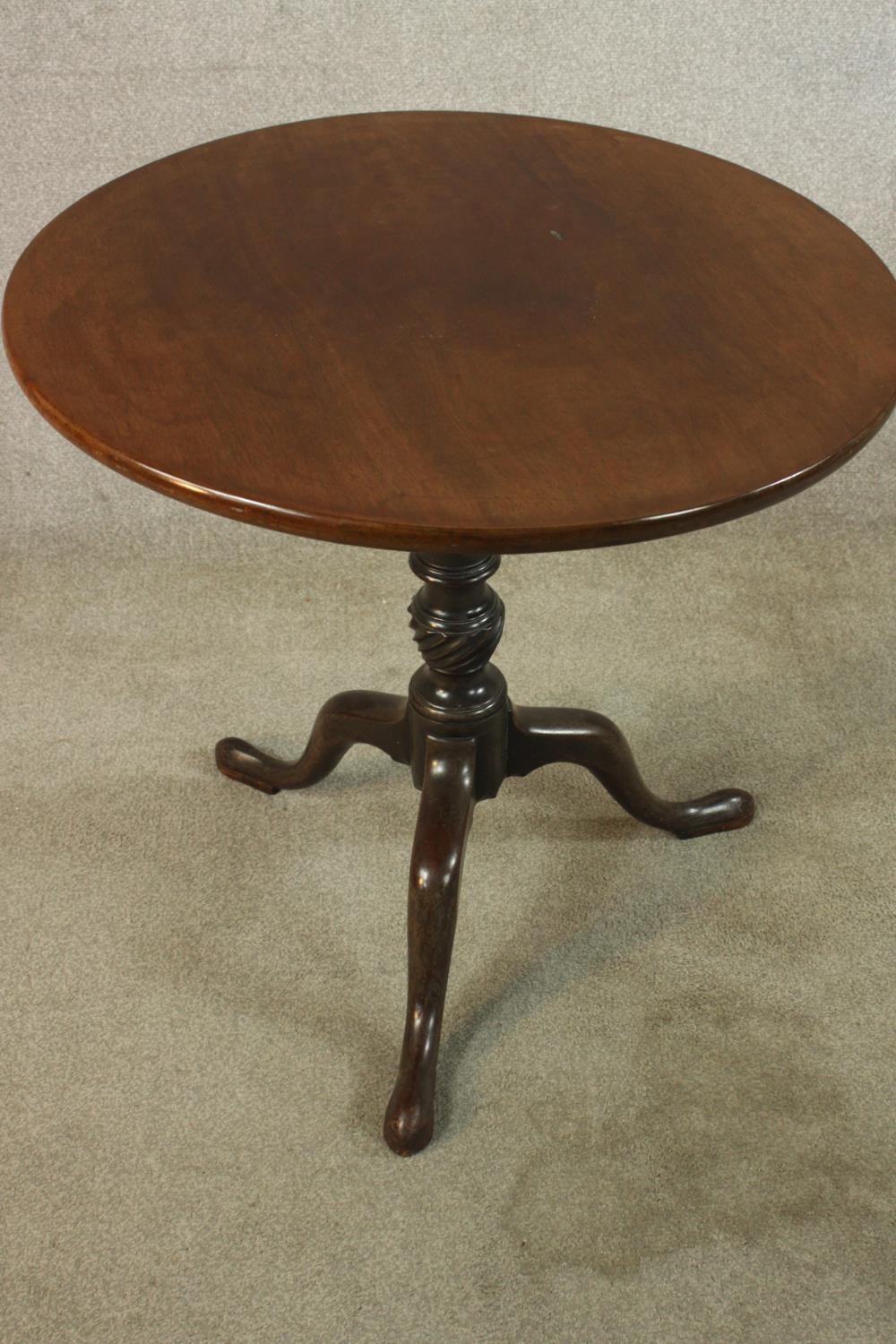 A George III mahogany tilt top tripod table, with turned central column raised on three outswept - Image 4 of 7