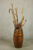 A brass coopered barrel form umbrella stand and a collection of eleven walking sticks and two