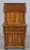 A late 19th century Asethetic style oak tambour fronted dentist/collectors cabinet, opening to