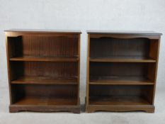 A pair of 20th century mahogany open bookcases, raised on shaped on plinth base and shaped bracket