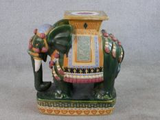 A painted ceramic elephant stool in brown and green glaze. H.57 W.26 D.46cm
