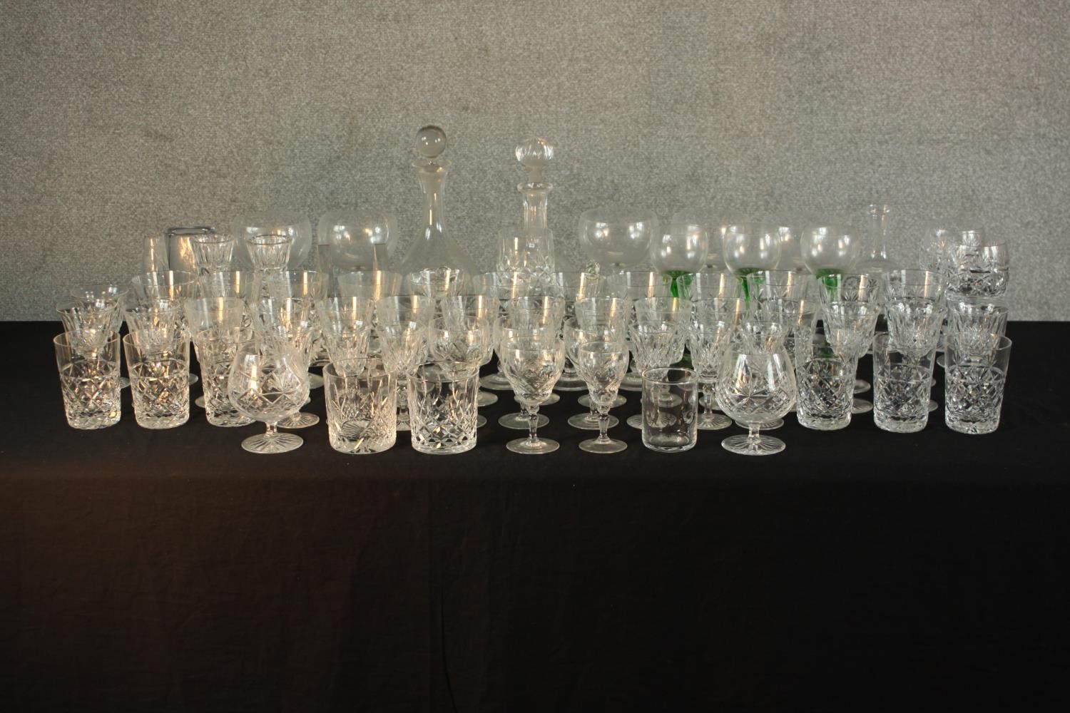 Aprroximately fifty mid / late 20th assorted cut glass drinking glasses together with decanters. H.