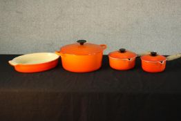 Four painted castiron Le Creuset cooking pots comprising of two lidded saucerpans, lidded