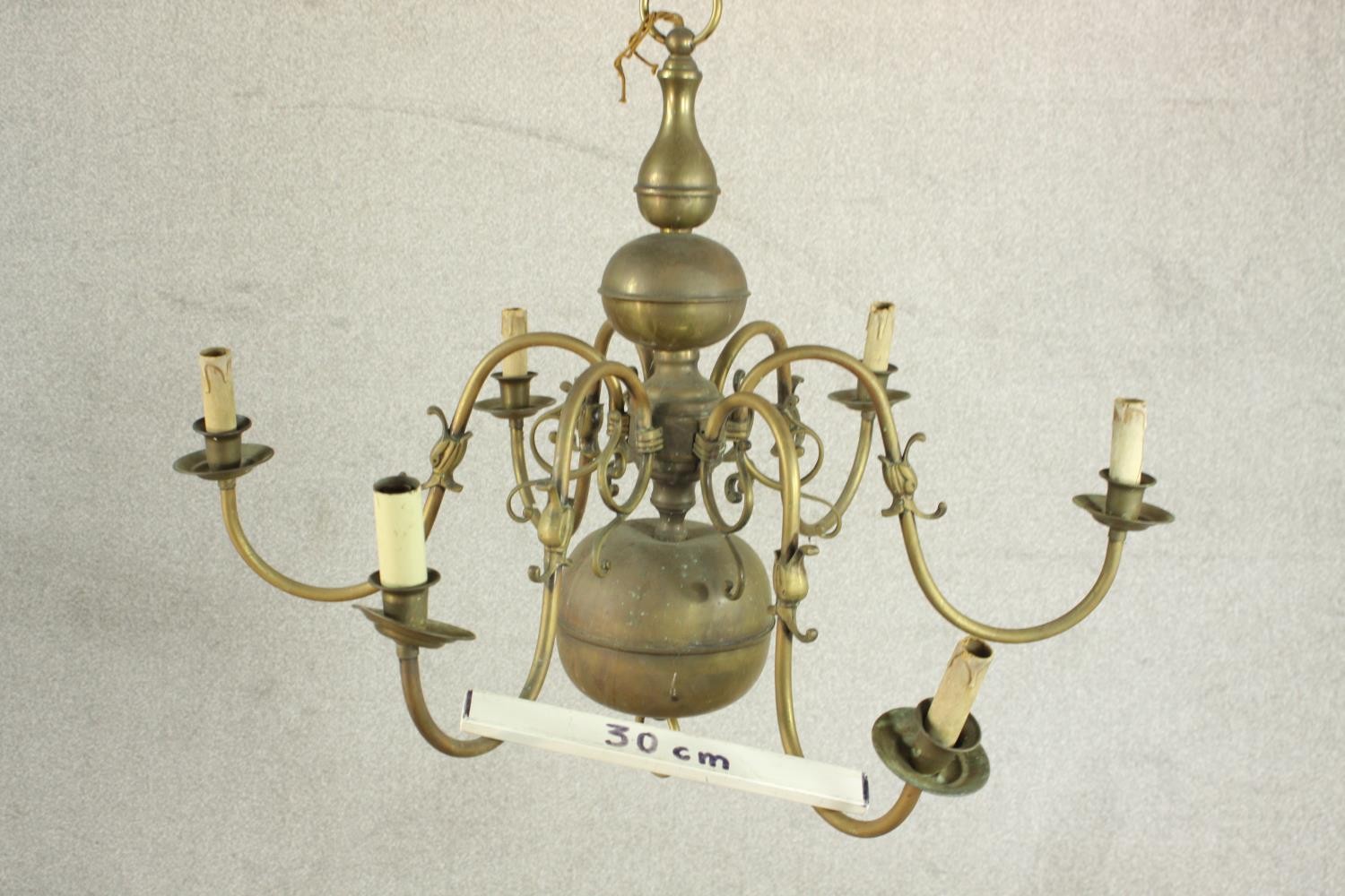 A 20th century Dutch style six branch brass chandelier with scroll arms. Damaged. H.70 Dia.42cm. - Image 4 of 8