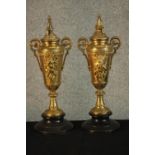 A pair of late 19th century French gilt metal twin handled urn form candlesticks on ebonised