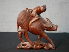 A 19th/early 20th century Chinese hardwood carved figure of man on the back of an oxen with glass