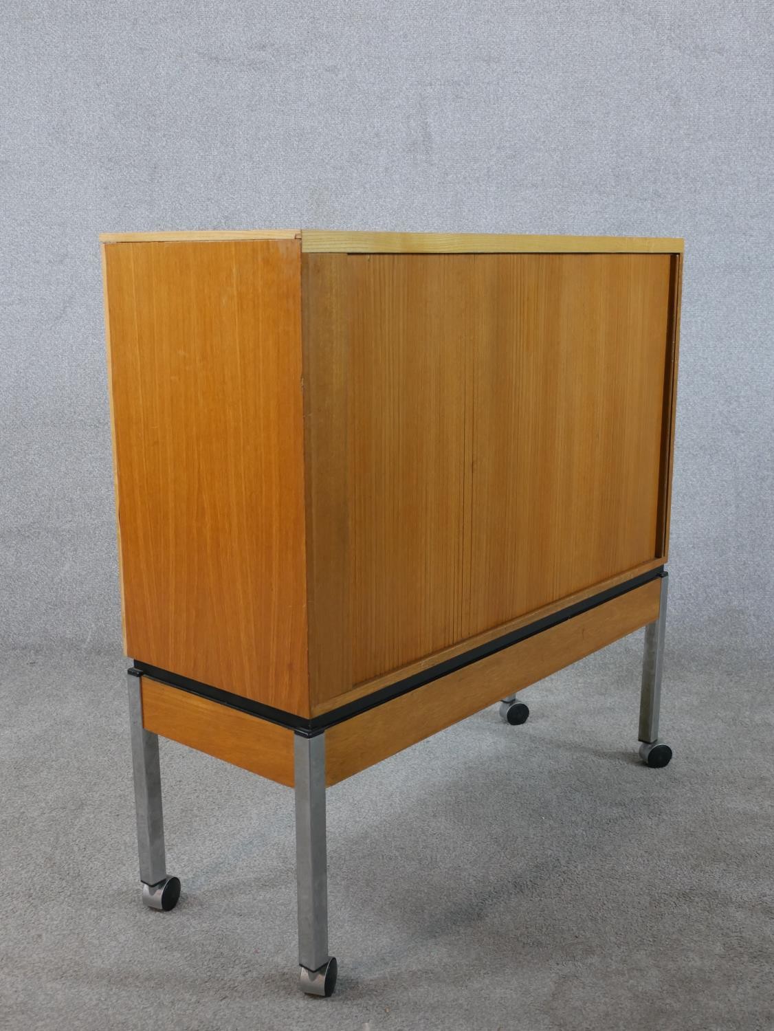 A late 20th century teak tambour fronted cabinet, opening to reveal shelves, raised on square - Image 5 of 6