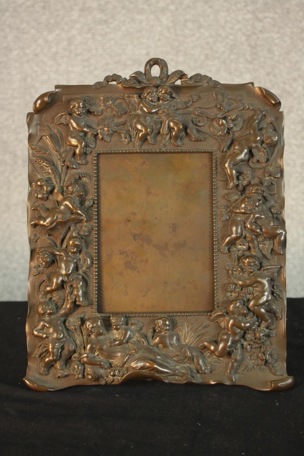 A late 19th/early 20th, possibly Italian cast bronze easel picture frame, with fiigural and putti