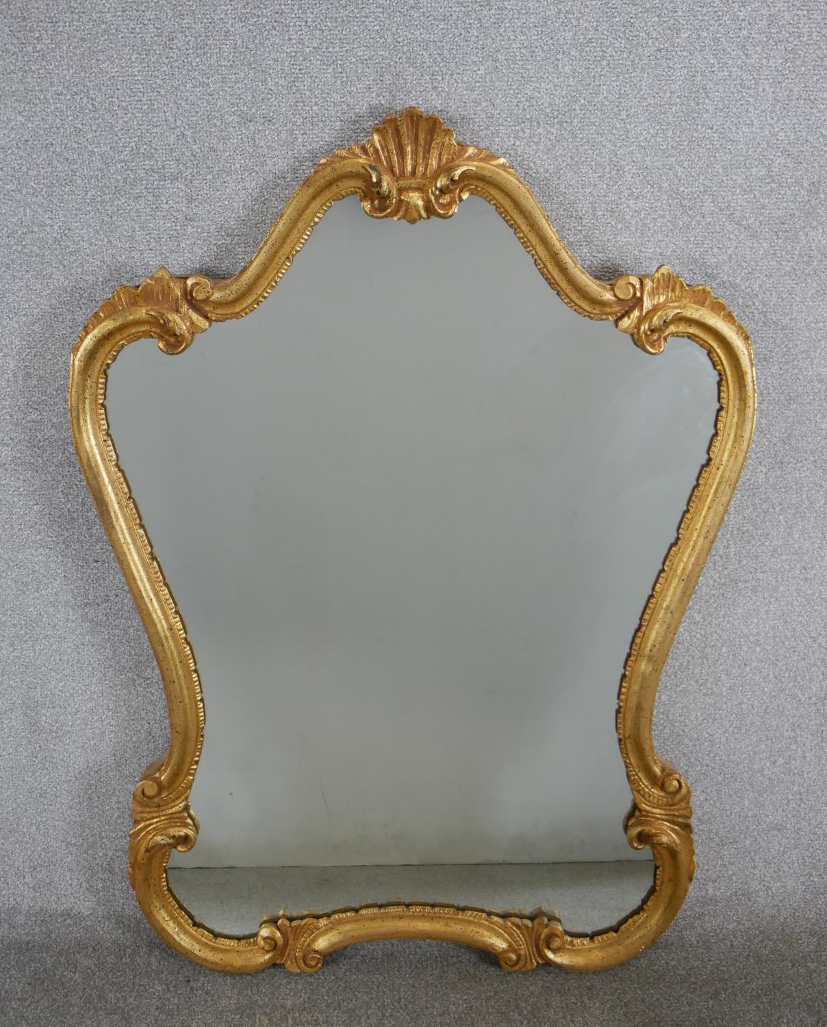 A 20th century Italian gilt framed cartouche shaped wall mirror. H.103 W.72cm