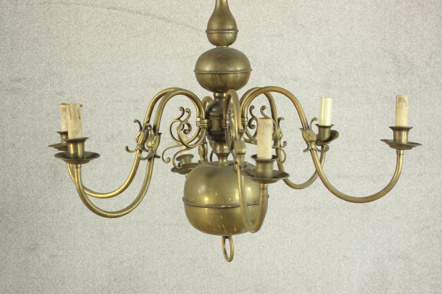 A 20th century Dutch style six branch brass chandelier with scroll arms. Damaged. H.70 Dia.42cm. - Image 2 of 8