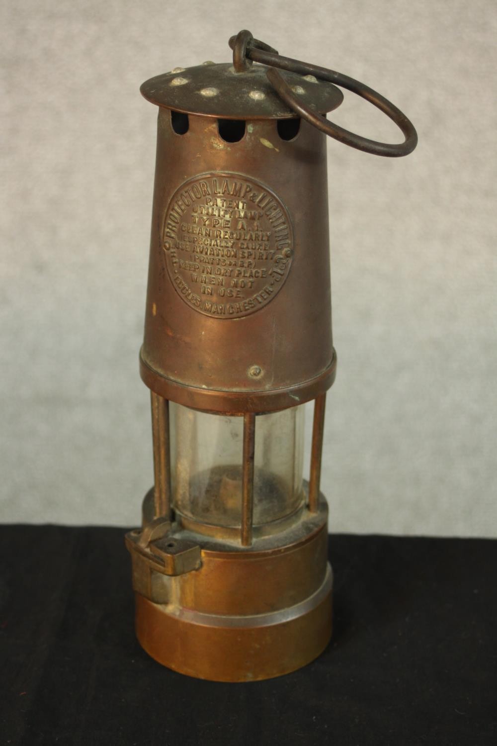 An early 20th century copper Type 1A miners lamp, with swing handle and embossed plaque to the