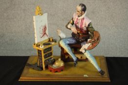 A 20th century Italian Capodimonte pottery figure of an artist painting with a cat, raised on