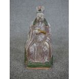 A Chinese painted pottery figure of a seated bearded figure on raised square plinth. H.15 W.26 D.