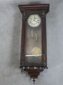 A late 19th / early 20th century oak cased regualator style wall clock, the white dial with black