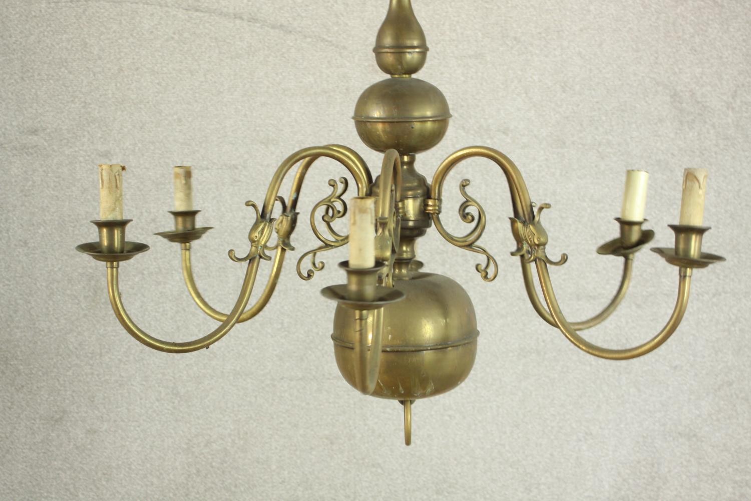 A 20th century Dutch style six branch brass chandelier with scroll arms. Damaged. H.70 Dia.42cm.