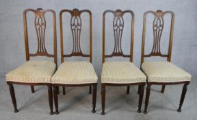 A set of four Edwardian inlaid mahogany framed chairs, with pierced splat backs and stuffover