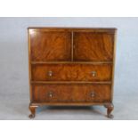 A circa 1930s figured walnut side cabinet, with two cupboard doors enclosing a shelf, over two