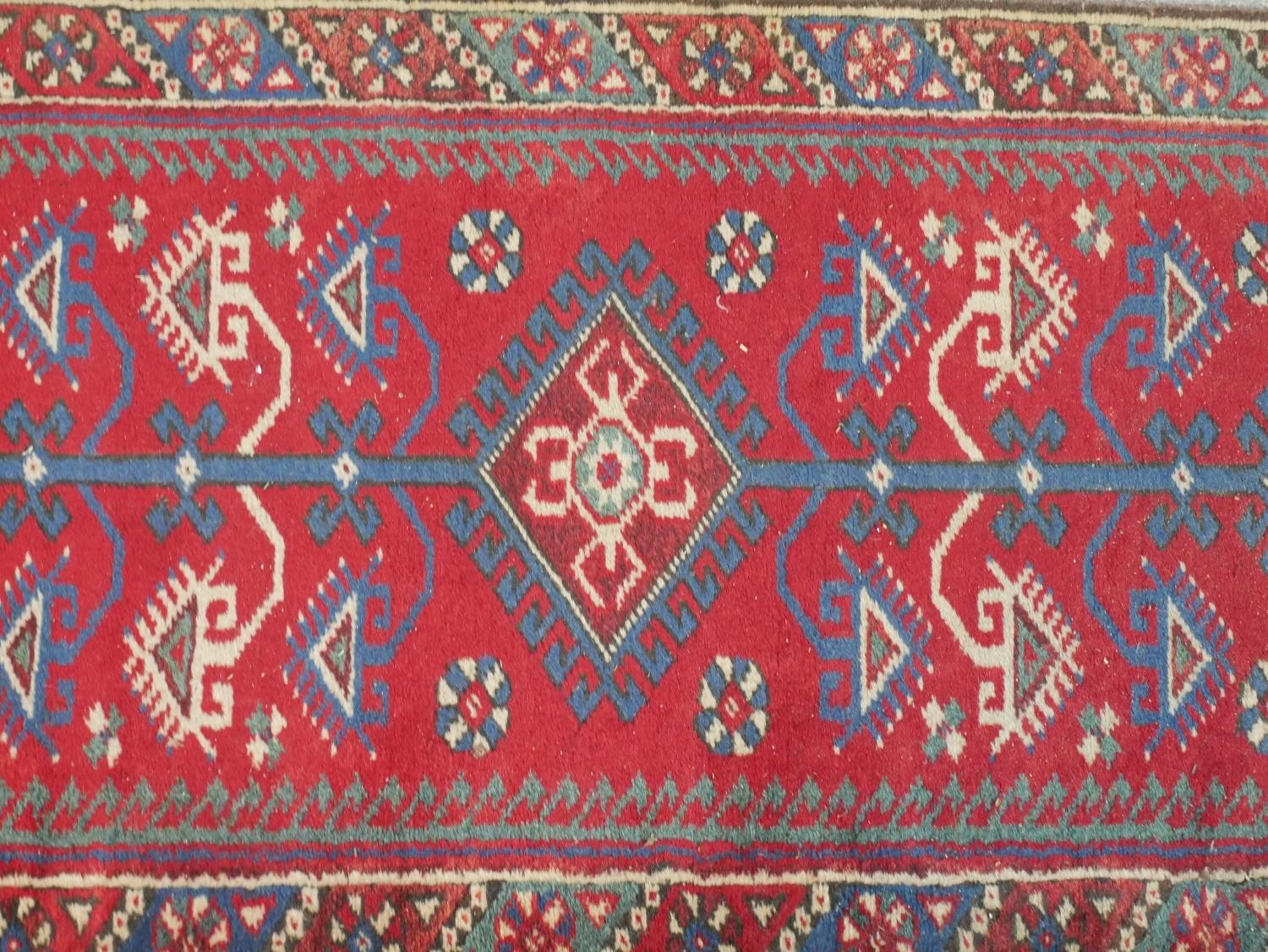 A 20th century red ground Heriz style runner with three central diamond lozenges within a - Image 3 of 4