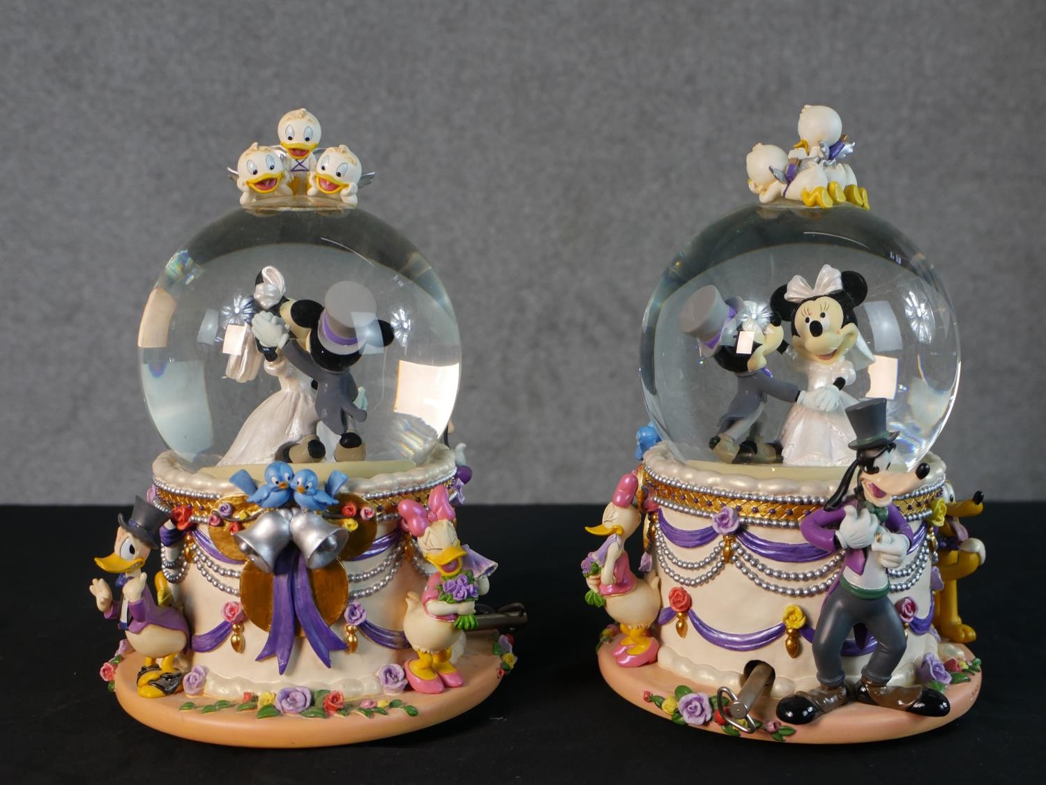 A pair of contemporary Mickey and Minnie Mouse Wedding March snow globes. H.22 Diam.15cm