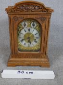 A late 19th /arly 20th century carved oak Anfang mantle clock, the brass dial with black Roman