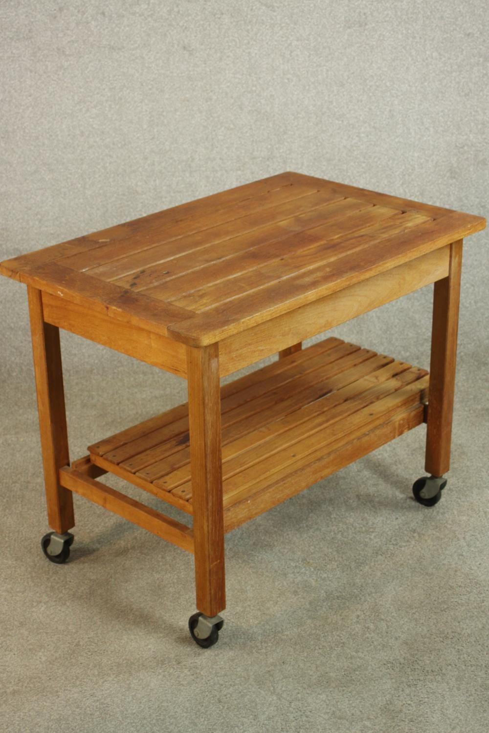 A mid 20th century slatted teak two tier trolley, raised on castors. H.62 W.76 D.50cm. - Image 3 of 4