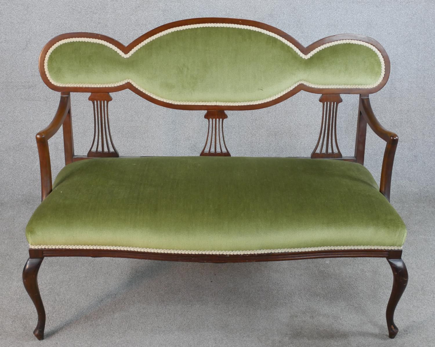 An Edwardian mahogany framed open arm settee with pierced splat back, with green upholstered seat