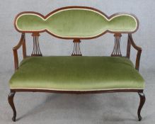 An Edwardian mahogany framed open arm settee with pierced splat back, with green upholstered seat