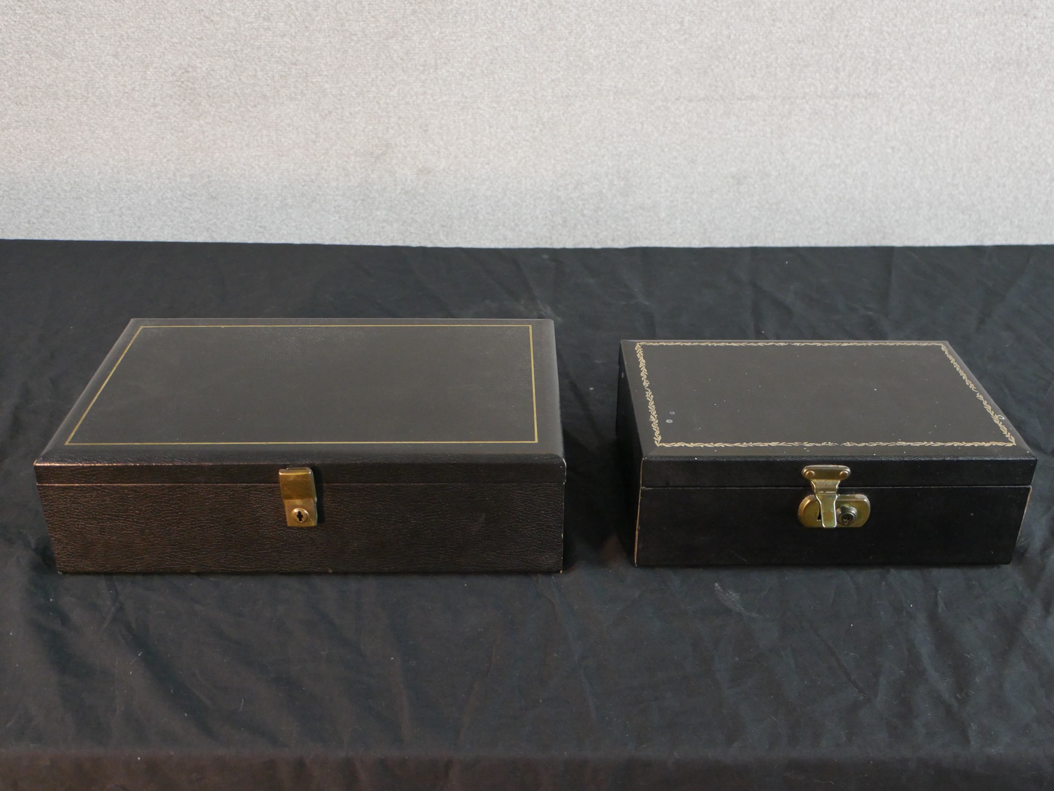 Two mid to late 20th century black faux leather jewellery boxes, one fitted and lined with red