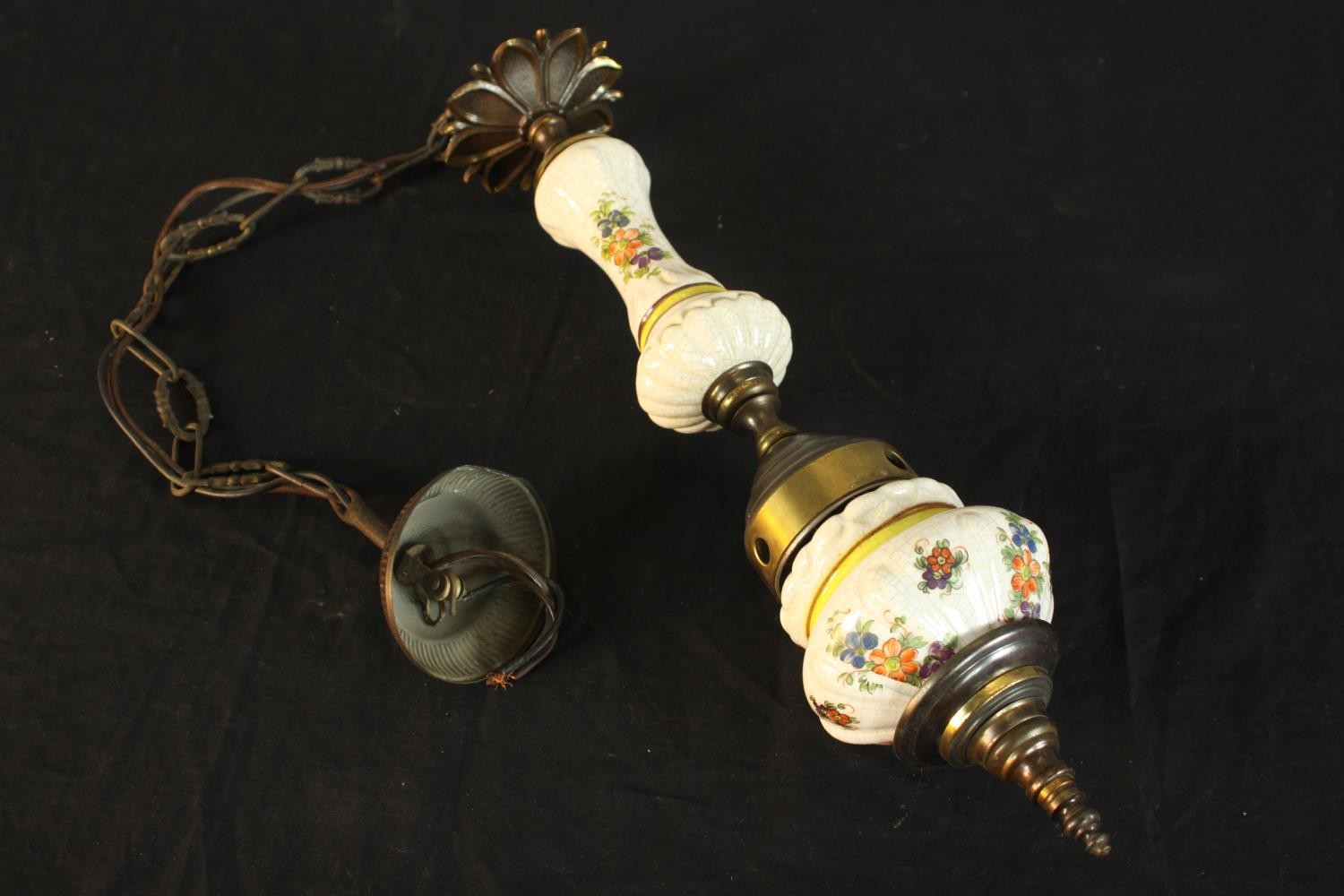 An early 20th century porcelain and brass ceiling pendant light, decorted with sprays of flowers.