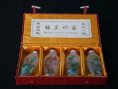 A contemporary set of four painted Chinese glass scent bottles, each painted with various flowers,